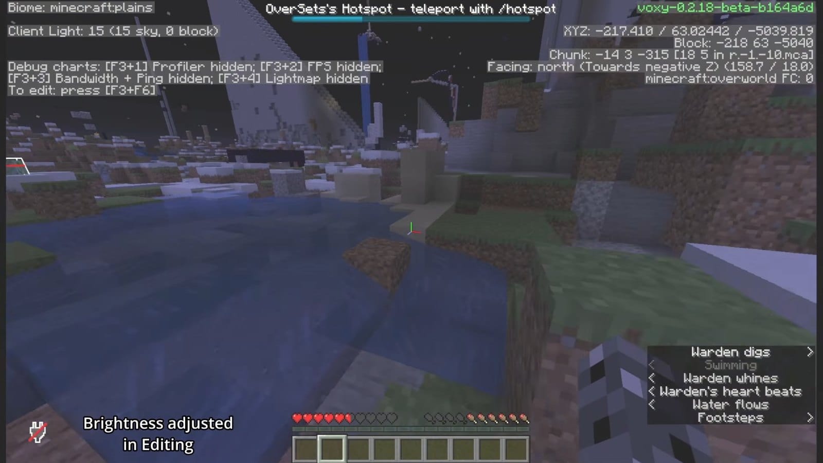 Night-time plains on 6b6t about 5,000 blocks from spawn, with a pool of water, grass and snow under tall ruined towers.