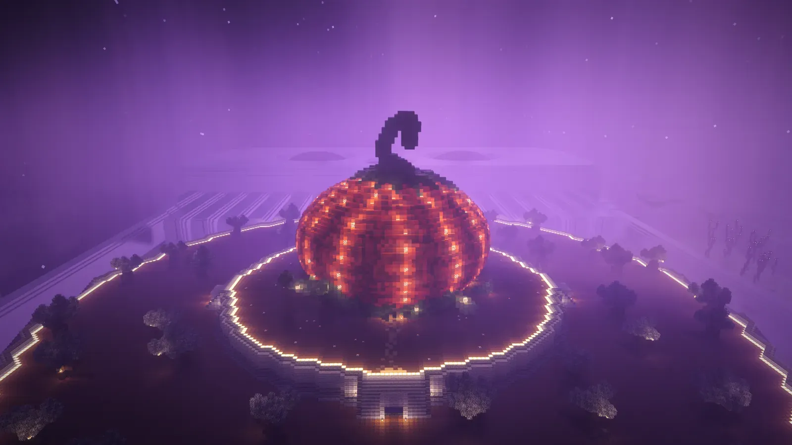 A giant glowing pumpkin on a round platform ringed with lights, seen from above under a purple sky